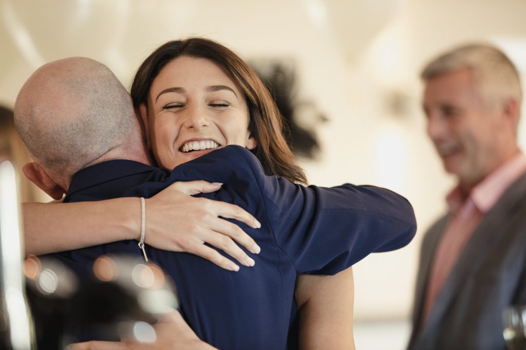 daughter hugging her father at a wedding