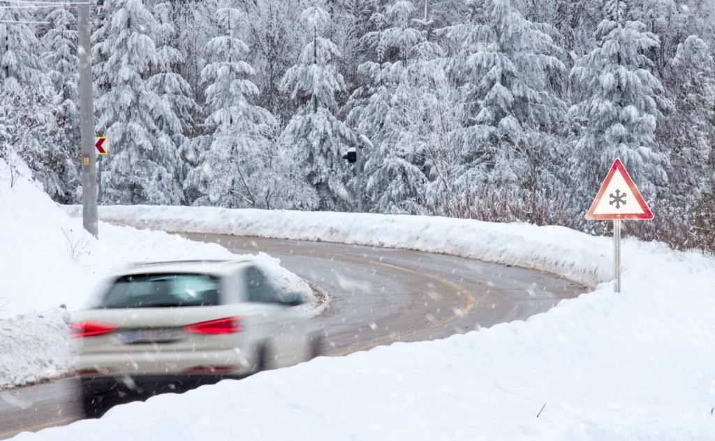 A car driving through danger snowy conditions which could result in damages