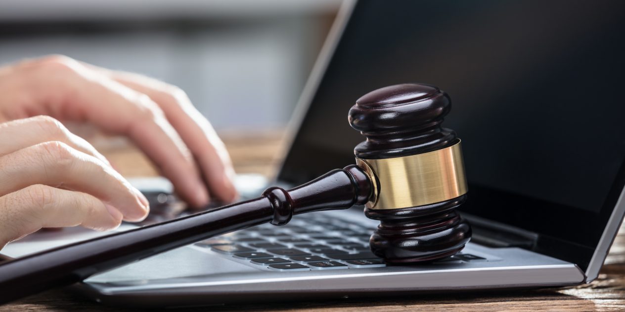 A gavel and computer emphasizing the search for legal council