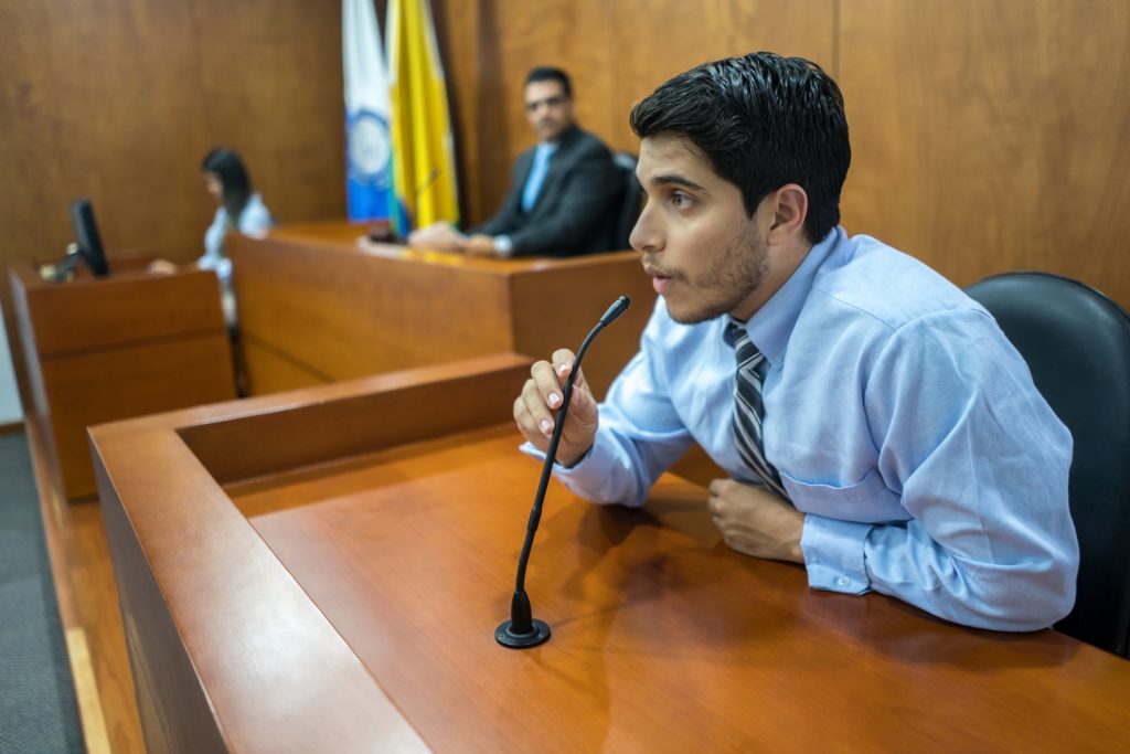 Portrait of a male witness addressing the courtroom in a trial - legal system concepts