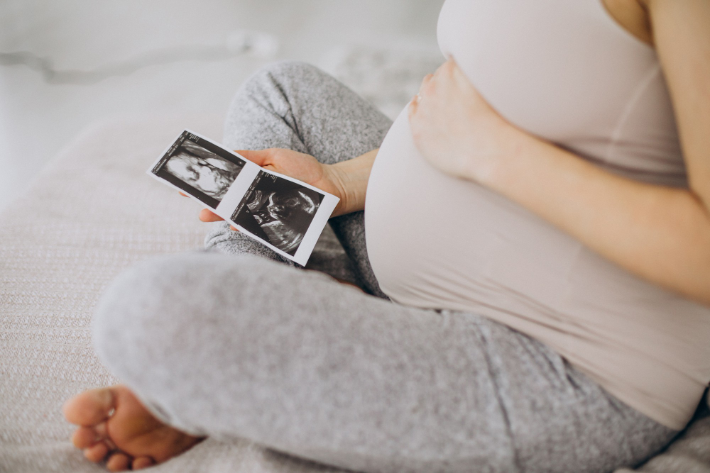 pregnant woman seeing ultrasound photo on bed