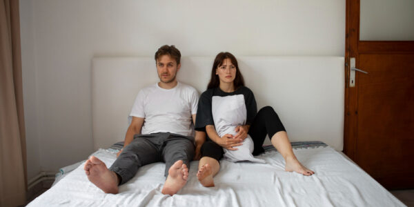 Couple sitting on bed