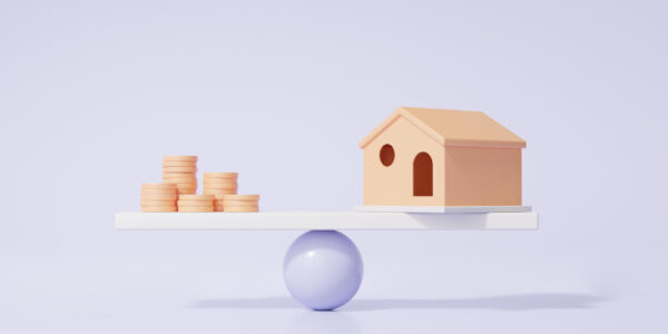 wooden house and coins balancing