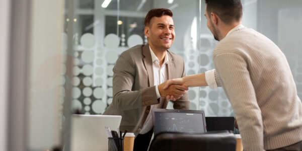 two business men shaking hands in an office